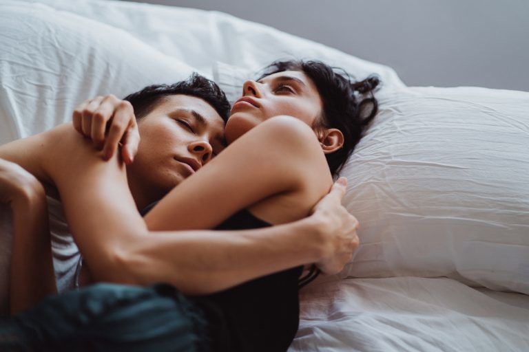 Women cuddling in bed