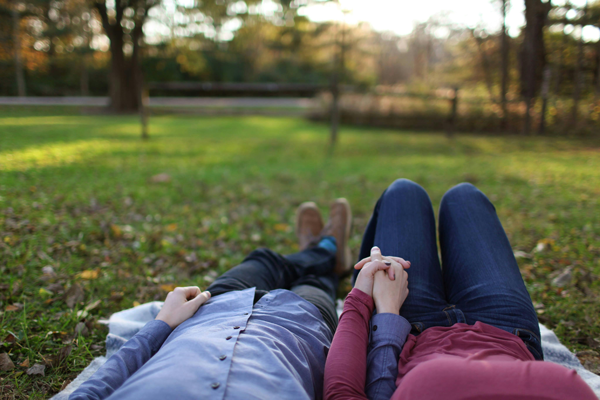Couple laying in park holding hands