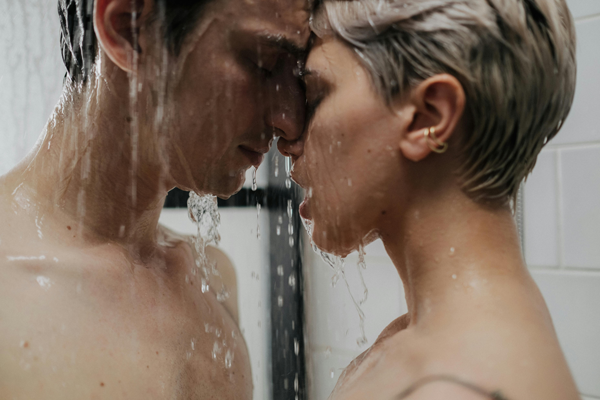 man and woman in shower kissing.